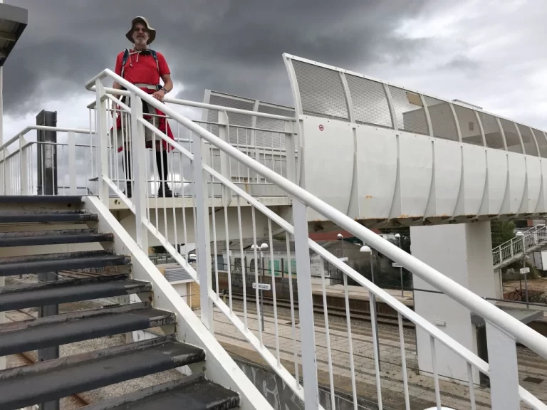 Camino passing over train tracks at station stairs