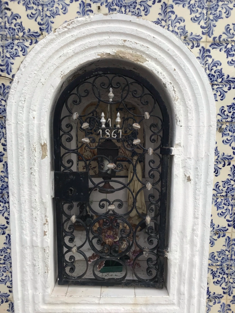 roadside shrine surrounded by painted tiles