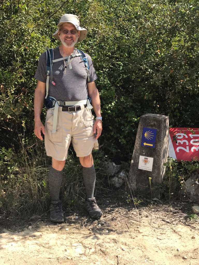 Richard beside a Camino marker