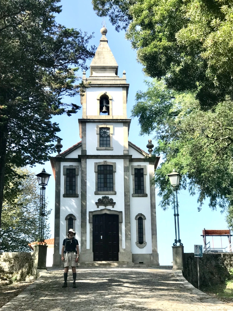 Chapel of San Ovidio with views toward the ocean and rubber trees in the yard