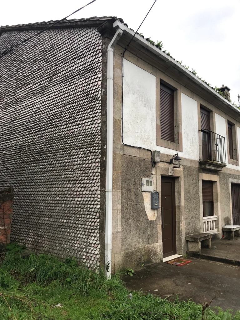 shells cover the side of this house near Santiago de Compostela